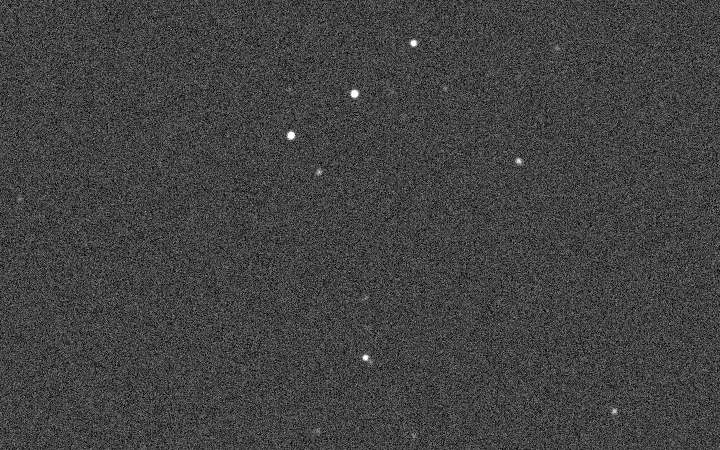 a grainy grey frame in which a handful of bright stars stand out of the noise